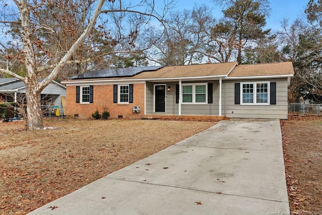 single story home with crawl space, roof mounted solar panels, and brick siding