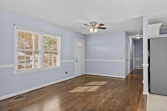 spare room featuring baseboards, visible vents, and dark wood-style flooring