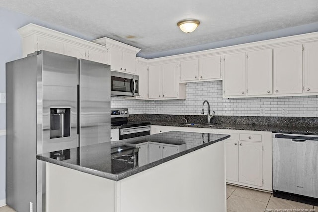 kitchen with white cabinetry, appliances with stainless steel finishes, decorative backsplash, and a sink