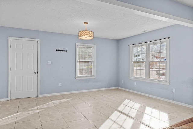 unfurnished room with visible vents, a textured ceiling, baseboards, and light tile patterned floors