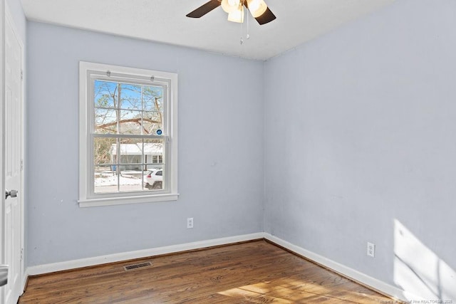 empty room featuring baseboards, visible vents, ceiling fan, and wood finished floors