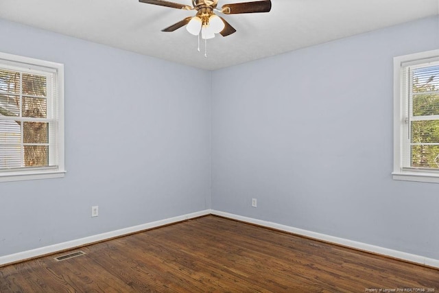 unfurnished room featuring ceiling fan, wood finished floors, visible vents, and baseboards