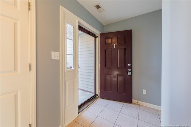 foyer entrance with a wealth of natural light, visible vents, baseboards, and light tile patterned floors