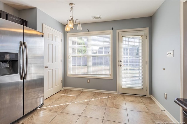 interior space featuring light tile patterned floors, visible vents, and baseboards