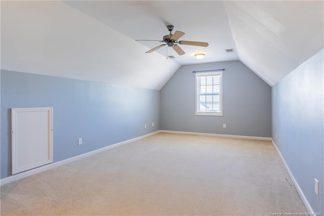 additional living space featuring baseboards, vaulted ceiling, a ceiling fan, and light colored carpet