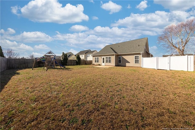 view of yard with a fenced backyard and a playground