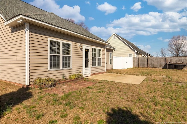 back of house with a patio, a lawn, fence, and roof with shingles