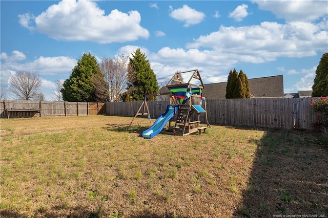 view of playground with a lawn and a fenced backyard