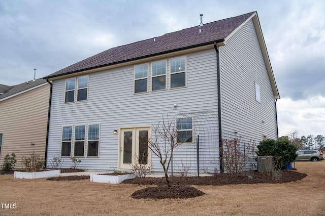 rear view of house featuring french doors and roof with shingles