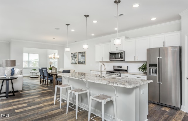 kitchen with stainless steel appliances, a sink, white cabinetry, an island with sink, and decorative light fixtures