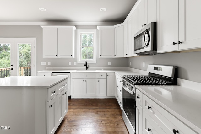 kitchen featuring stainless steel appliances, a sink, light countertops, and white cabinets