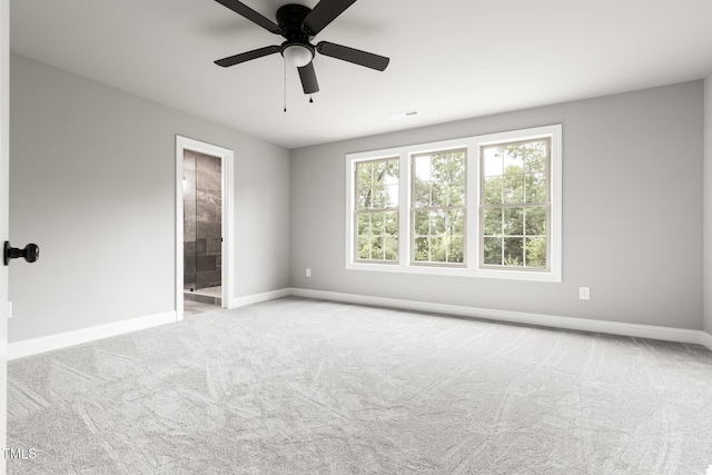 unfurnished room featuring a ceiling fan, light colored carpet, visible vents, and baseboards