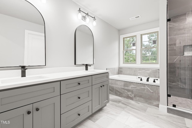 bathroom featuring a garden tub, a sink, visible vents, a shower stall, and double vanity