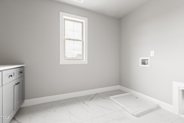 laundry room featuring marble finish floor, baseboards, washer hookup, and cabinet space