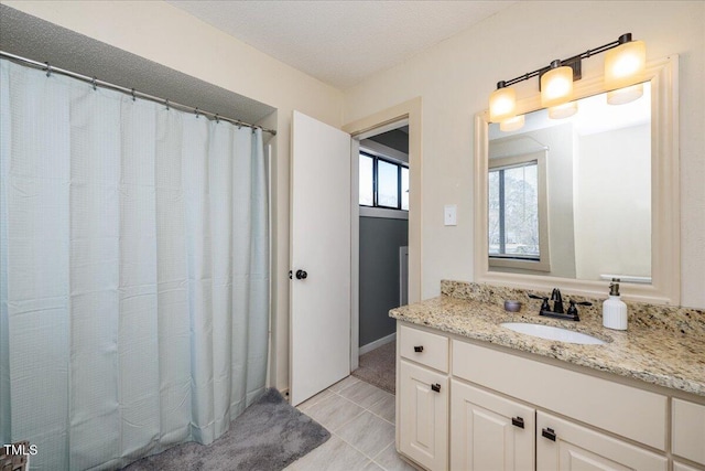 bathroom featuring curtained shower, vanity, a textured ceiling, and tile patterned floors