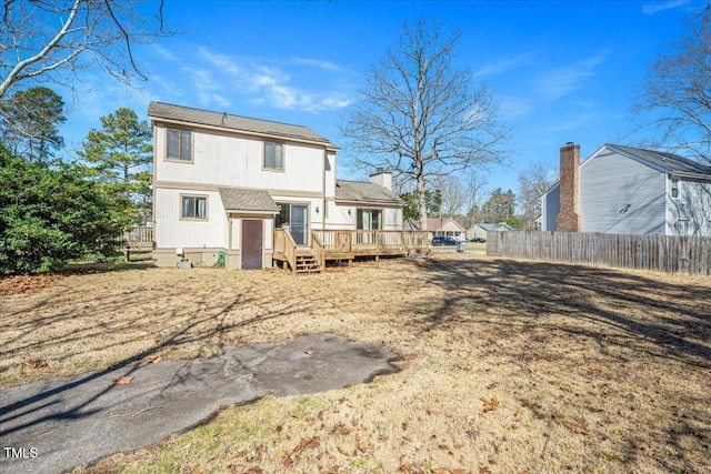 back of house with fence and a wooden deck