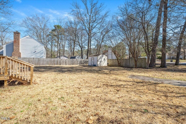 view of yard featuring fence private yard, a storage shed, and an outdoor structure