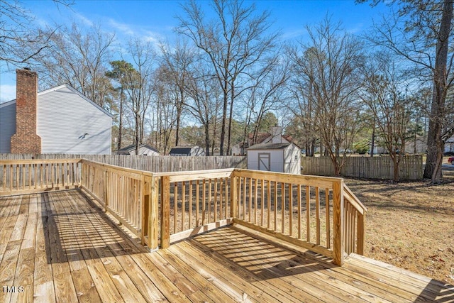 deck featuring a fenced backyard, an outdoor structure, and a shed