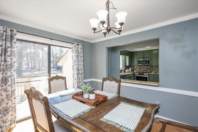 dining space with crown molding, a textured ceiling, wood finished floors, a chandelier, and baseboards