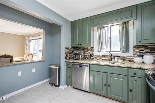 kitchen featuring stainless steel appliances, a sink, and green cabinetry