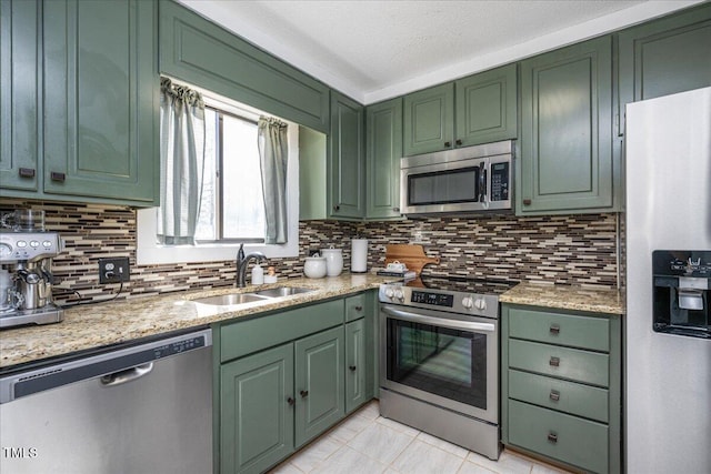 kitchen with stainless steel appliances, a sink, and green cabinets