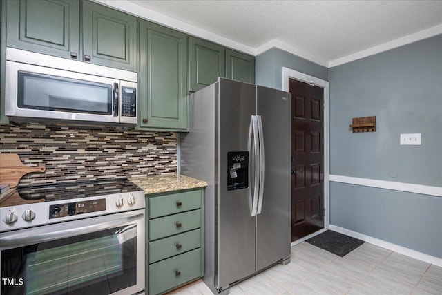 kitchen with stainless steel appliances, backsplash, green cabinets, a textured ceiling, and baseboards