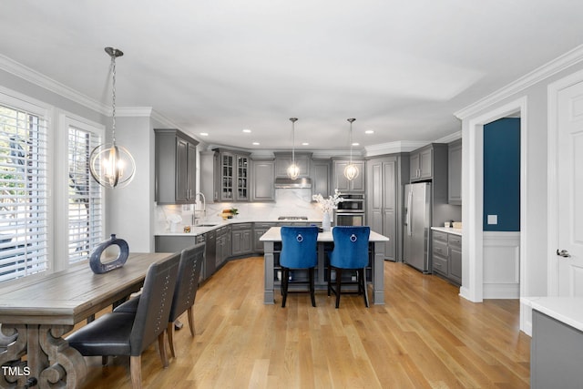 kitchen with glass insert cabinets, gray cabinets, light countertops, and appliances with stainless steel finishes