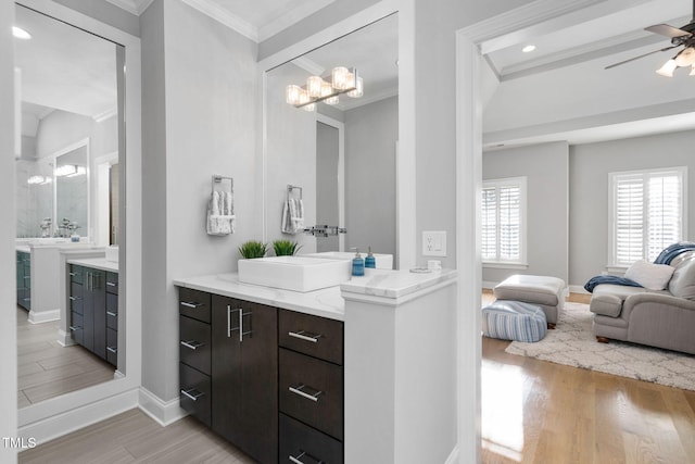 ensuite bathroom featuring connected bathroom, wood finished floors, vanity, a ceiling fan, and ornamental molding