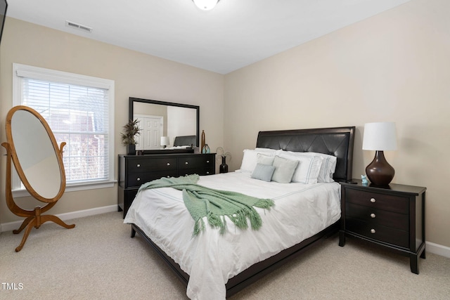 bedroom with baseboards, visible vents, and light colored carpet