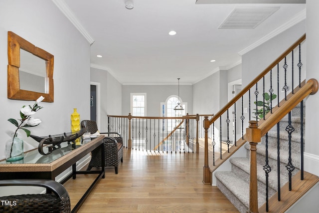 corridor featuring ornamental molding, light wood finished floors, visible vents, and recessed lighting