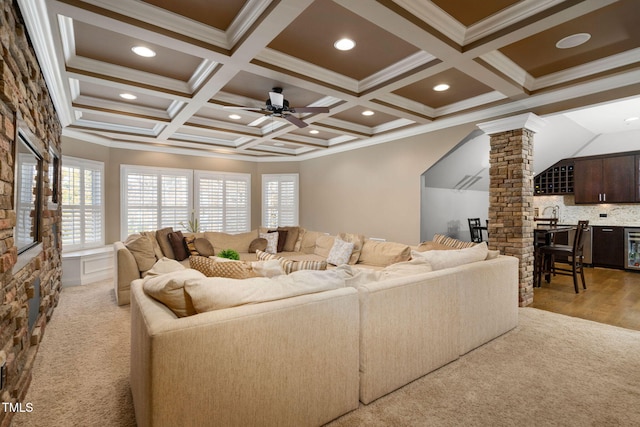 living area with ceiling fan, ornamental molding, coffered ceiling, and decorative columns