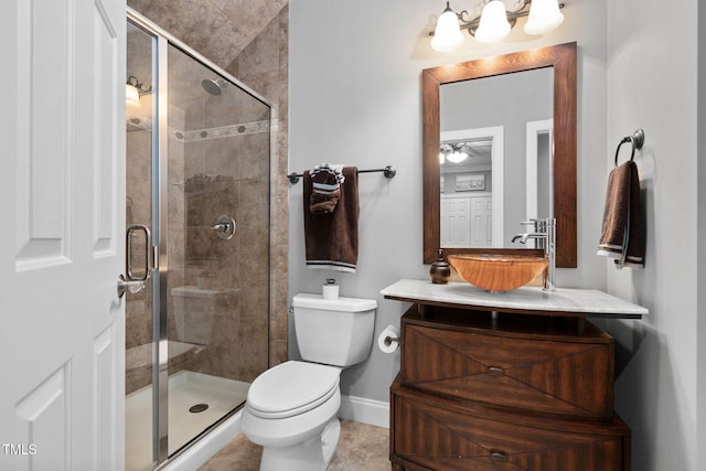 full bath featuring a stall shower, vanity, toilet, and baseboards