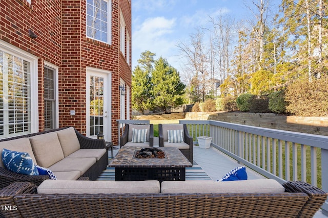 deck featuring an outdoor living space with a fire pit