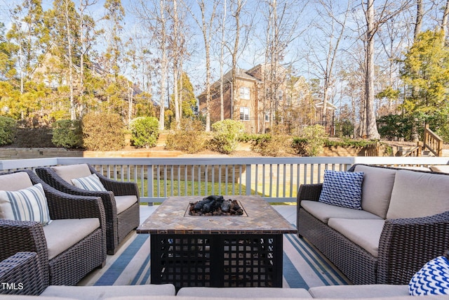 wooden deck featuring an outdoor living space with a fire pit