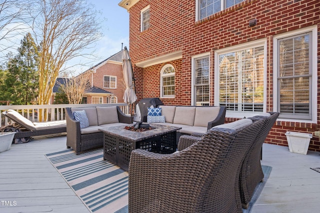 deck with an outdoor living space with a fire pit