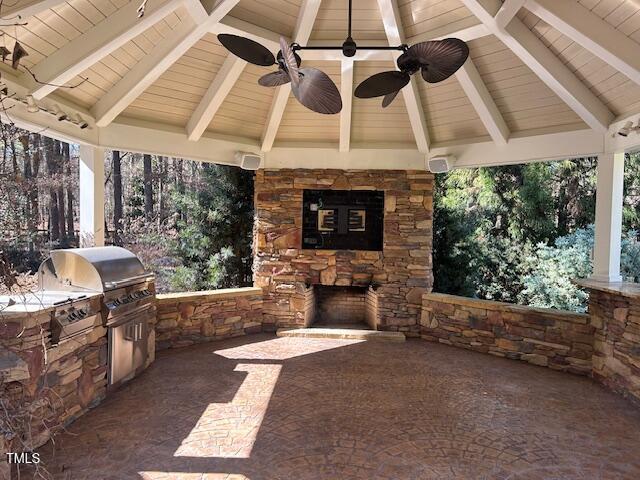view of patio / terrace with an outdoor stone fireplace, area for grilling, and a gazebo