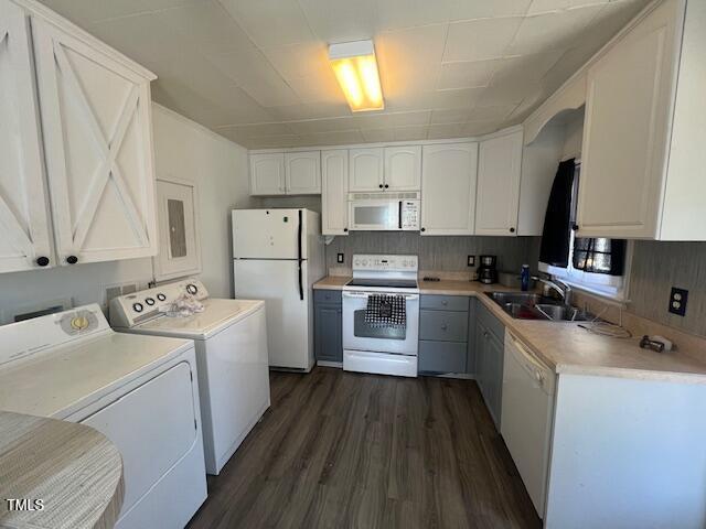 606 N Orange Ave, Dunn, NC 28334 - kitchen featuring separate washer and dryer, white appliances, a sink, white cabinetry, and light countertops