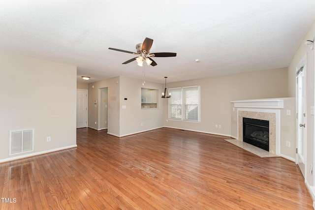 unfurnished living room with a fireplace, visible vents, baseboards, a ceiling fan, and light wood-type flooring