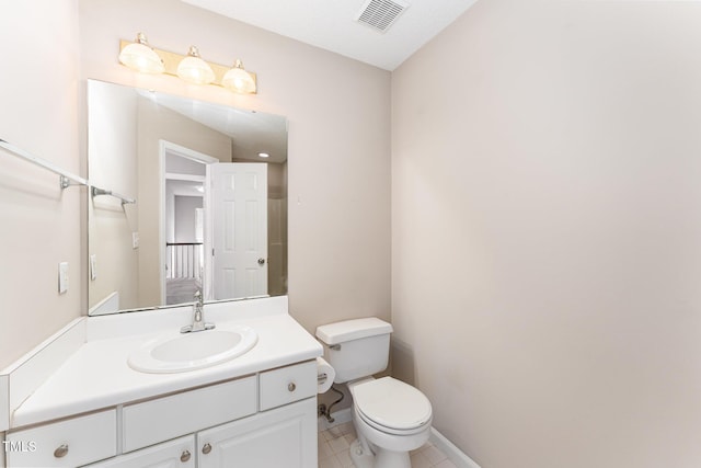 bathroom featuring toilet, vanity, baseboards, visible vents, and tile patterned floors