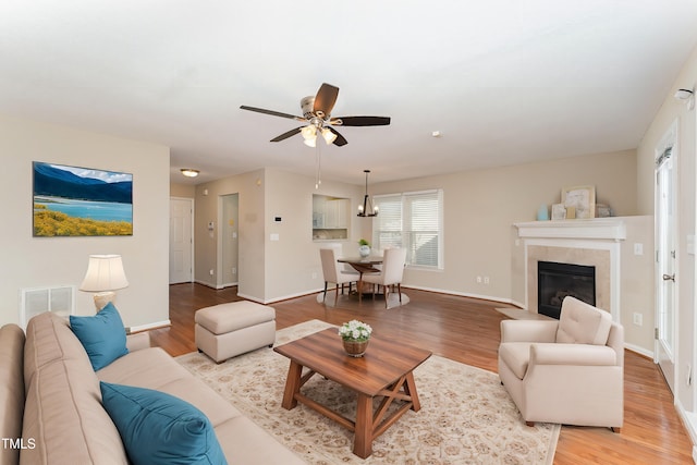 living room featuring light wood-type flooring, baseboards, and visible vents