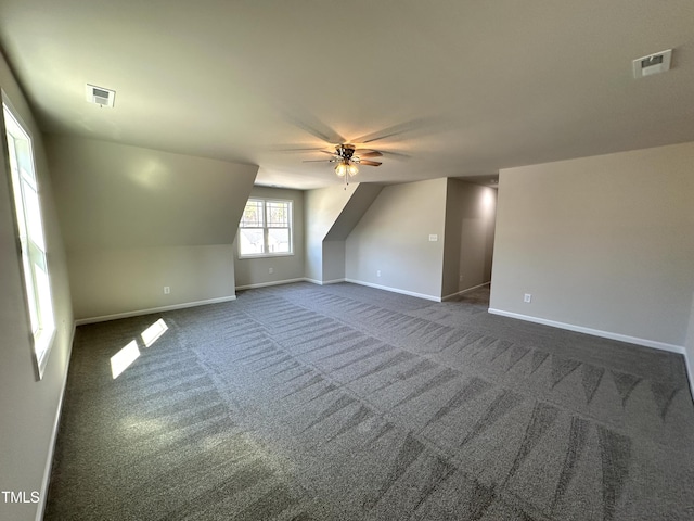 bonus room with visible vents, baseboards, a ceiling fan, and dark colored carpet