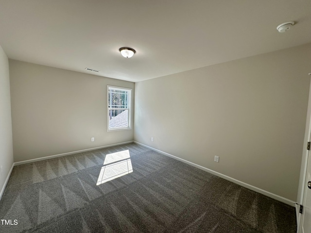 carpeted empty room featuring baseboards and visible vents