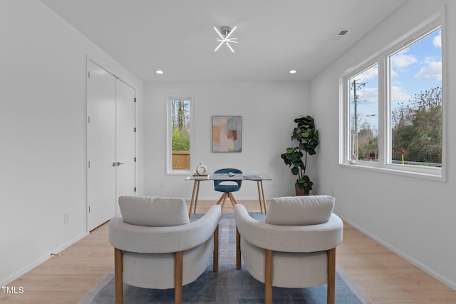 living area with baseboards, light wood-type flooring, visible vents, and recessed lighting