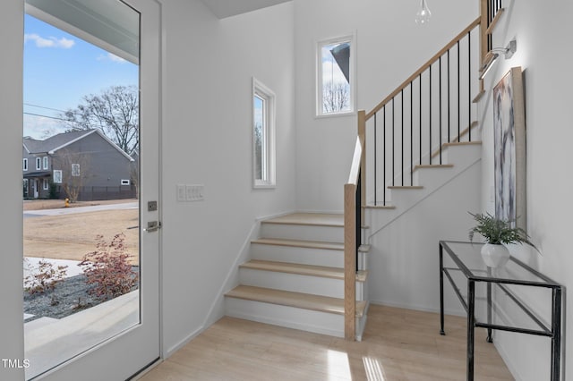 foyer featuring stairway, baseboards, and wood finished floors