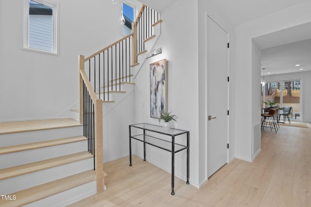 stairway with visible vents, baseboards, wood finished floors, and recessed lighting