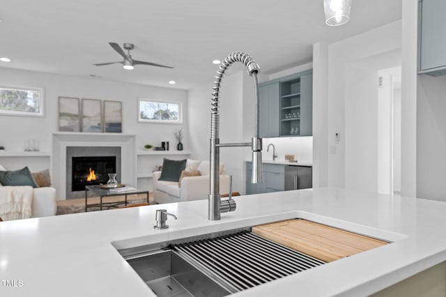 kitchen featuring a warm lit fireplace, light countertops, open floor plan, and recessed lighting