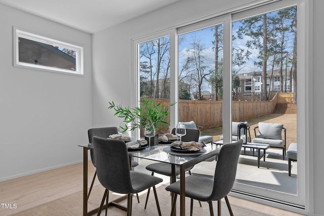 dining area with light wood finished floors and baseboards