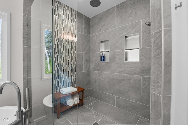 full bath featuring a soaking tub and a tile shower