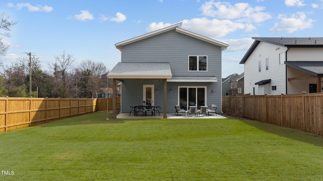 rear view of house featuring a fenced backyard, a shingled roof, a patio, and a yard