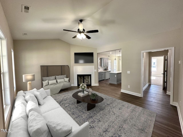living room with baseboards, a ceiling fan, dark wood-type flooring, and visible vents